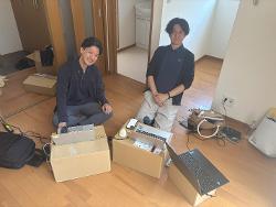 段ボールのテーブル（？）で作業するIさんとHさん